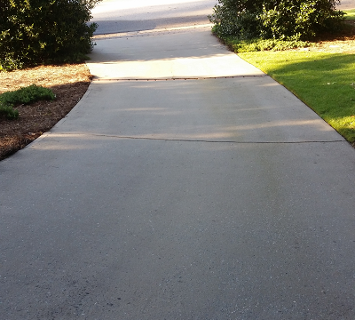 Pressure washing services in Peachtree City, Ga to remove black stains on concrete driveway.